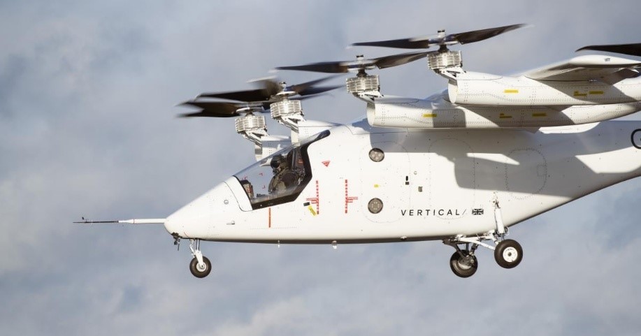 A small helicopter in flight, showcasing its spinning propellers against the backdrop of the sky